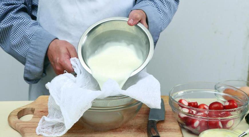 Переложите простоквашу в марлю или кухонное полотенце, завяжите мешочек и оставьте стекать на 1–4 часа. Чем дольше она будет стекать, тем плотнее получится текстура.