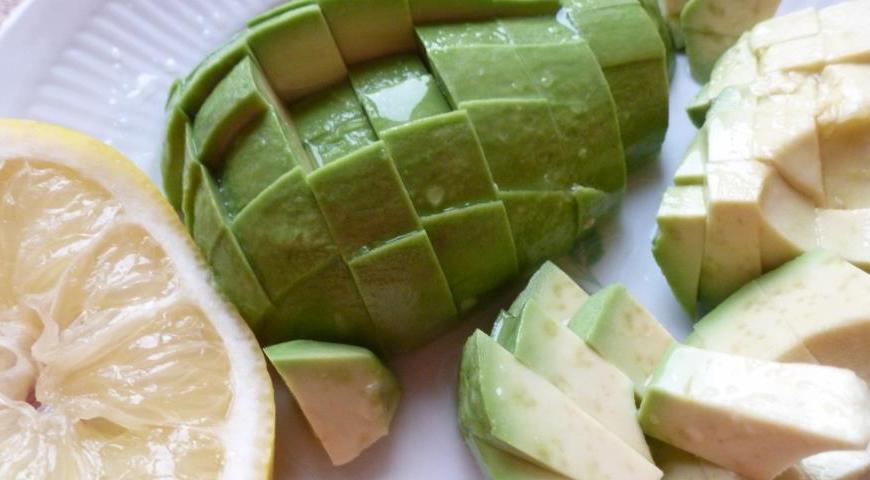 Очистите авокадо от кожуры и косточки, нарежьте кубиками. Сразу же сбрызните лимонным соком, чтобы не потемнело.