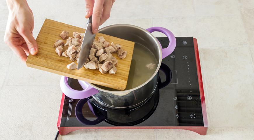Процедите полученный бульон. Снимите мясо с костей и нарежьте его на средние кусочки, верните в бульон.