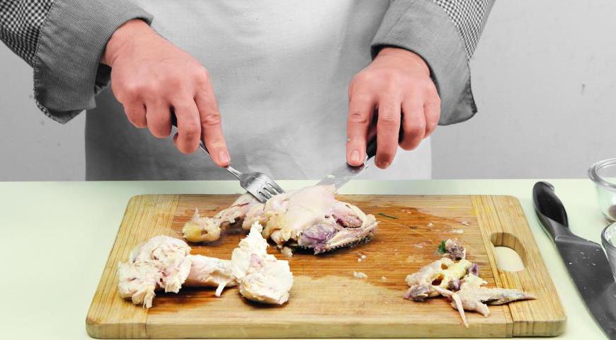 После варки аккуратно выньте курицу из кастрюли, отделите мясо от костей. Мясо поместите в миску, добавьте немного бульона и накройте пищевой пленкой, чтобы оно оставалось сочным. Кости верните обратно в кастрюлю и продолжайте варить бульон еще 1,5 часа. По окончании процедите его через сито.