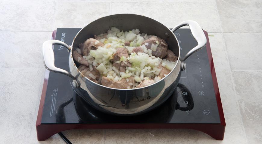 Очистите лук, мелко нарежьте и добавьте к мясу. Продолжайте готовить, периодически помешивая, пока лук не станет мягким и золотистым. По мере необходимости подливайте немного горячей воды, чтобы мясо равномерно протушилось.