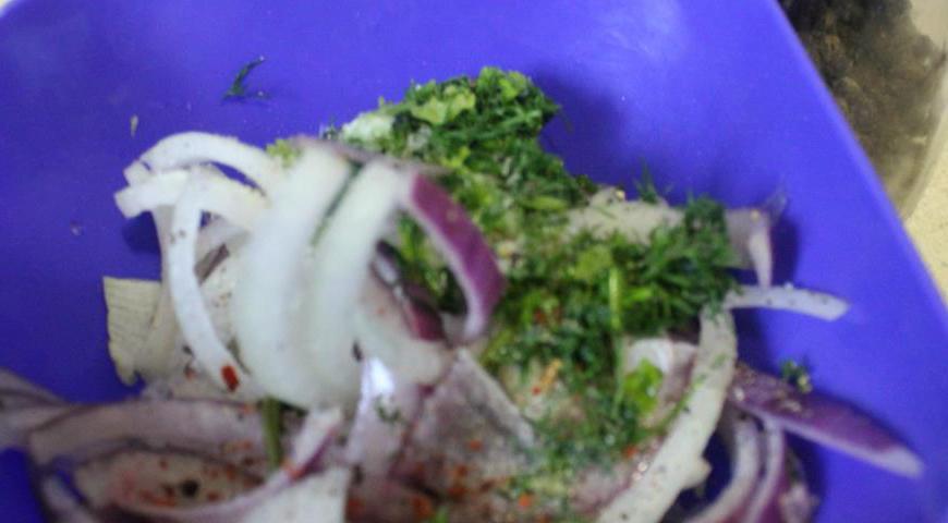 Пока мясо запекается, подготовьте маринованный лук: нарежьте красный и репчатый лук тонкими полукольцами, добавьте измельченную кинзу и перец. Разомните руками, добавьте масло, соевый соус, уксус и сахар, затем хорошо перемешайте.