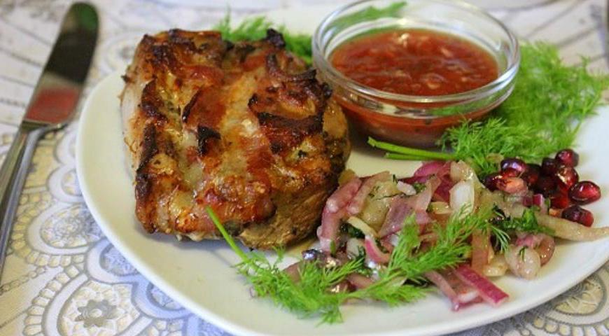 Подавайте готовое мясо с маринованным луком, томатным соусом, свежей зеленью и зернами граната для яркого вкуса и красивой подачи.