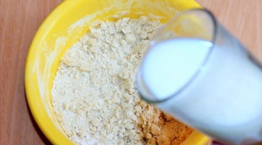 Влейте теплый кефир в миску и замесите мягкое, не липнущее к рукам тесто. Не стоит вымешивать слишком долго — это может сделать выпечку плотной.