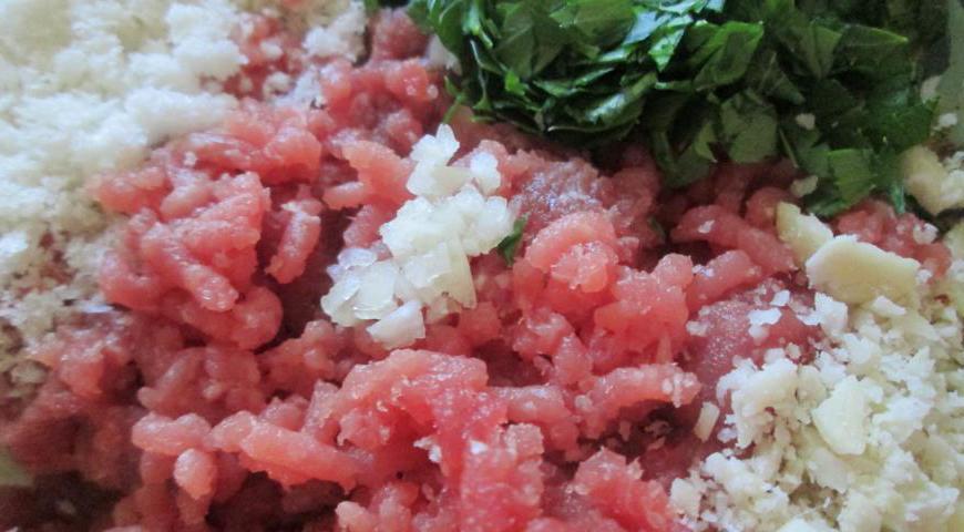 Для начинки смешайте говяжий фарш, хлебные крошки, измельченную зелень сельдерея и специи. Добавьте яйцо, соль и перец. Хорошо перемешайте массу, затем введите молотый арахис и снова соедините до однородности.