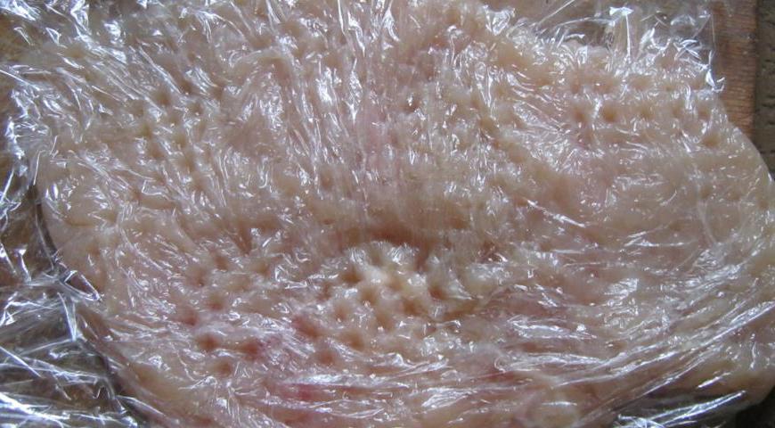 Выбирайте крупные куски куриной грудки. Оберните каждое филе пищевой пленкой и аккуратно отбейте молотком до тонкого состояния, следя за тем, чтобы мясо не порвалось.