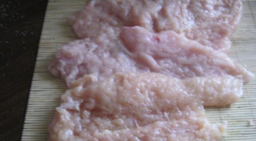 Посолите и поперчите мясо с обеих сторон. Расположите куски филе в ряд, немного перекрывая друг друга примерно на четверть длины.