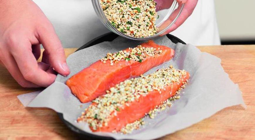 На противень, застеленный пергаментом, положите куски лосося. Посыпьте каждый кусок ореховой смесью, сверху сбрызните оливковым маслом. Запекайте в духовке около 10 минут или до готовности.
