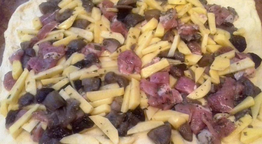 Противень смажьте растительным маслом. Раскатайте чуть больше половины теста и аккуратно выложите его на противень, формируя ровный пласт.