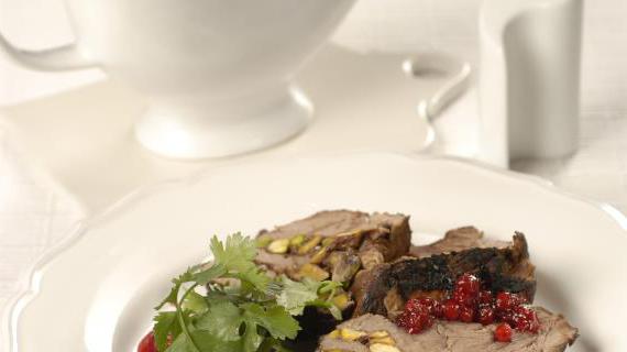 Ароматный стейк из говядины с брусничным соусом, овощами и фисташками