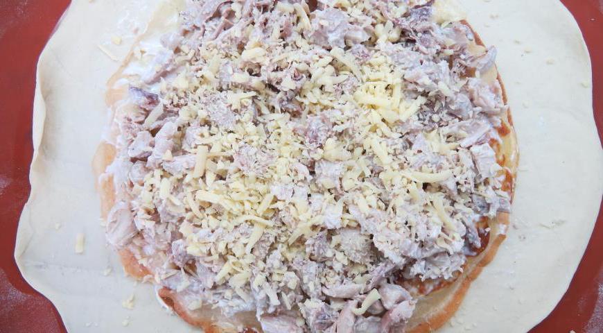 Уложите второй блинчик, смажьте соусом и выложите половину куриной начинки. Посыпьте сыром.