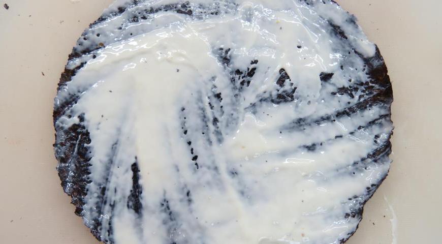 На лист нори намажьте тонкий слой сливочного сыра и аккуратно положите его на рис, сыром вниз.