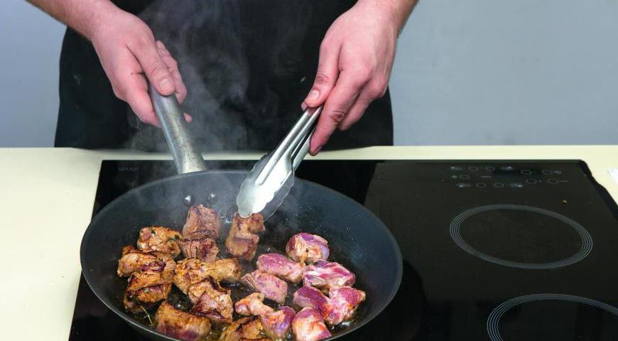 Достаньте мясо из маринада и аккуратно обсушите бумажными полотенцами. Разогрейте сковороду с толстым дном, добавьте масло и обжаривайте мясо порциями до образования золотистой корочки. Не стоит перегружать сковороду, чтобы мясо не потемнело. Готовое мясо выложите на тарелку и оставьте остывать на несколько минут.