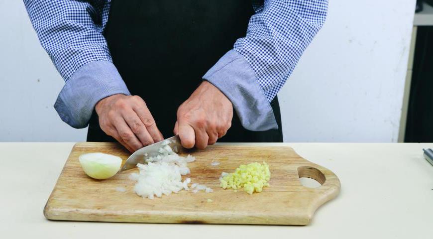 В процессе запекания мяса приступайте к приготовлению соуса. Тщательно очистите и натрите на мелкой терке имбирь. Красный лук также очистите и нарежьте максимально мелкими кубиками. Влейте уксус и добавьте мед в небольшой сотейник, всыпьте лук и нагревайте на минимальном огне в течение 12 минут.