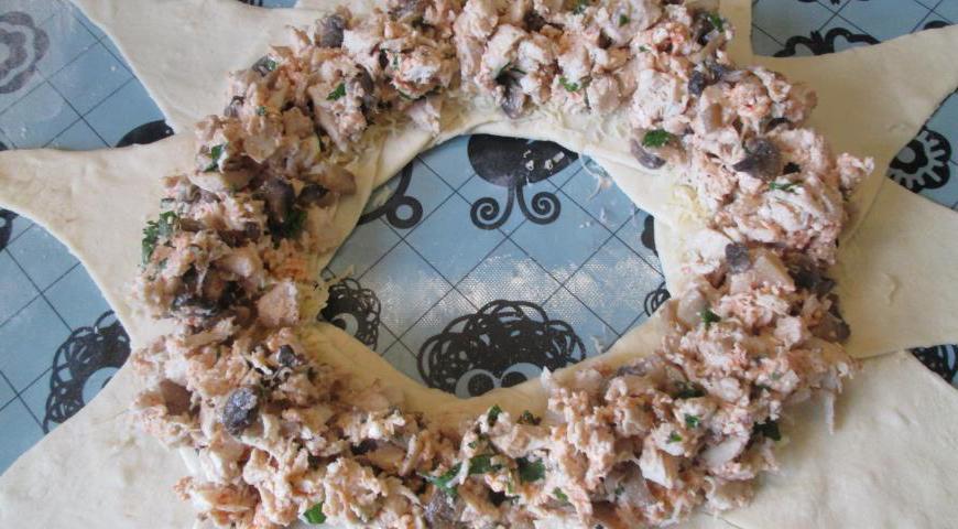 На каждый треугольник с сыром выложите подготовленную куриную начинку, распределяя её равномерно.