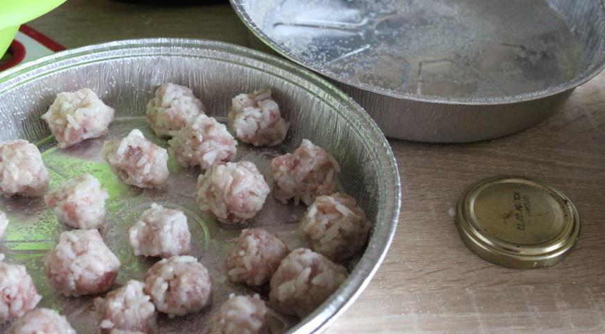 Формочки смазать растительным маслом и посыпать манной крупой. Из фаршевой массы скатать небольшие шарики и выложить их в формы.