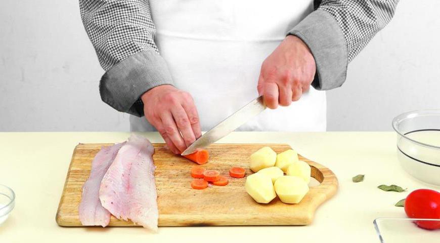 Нарежьте филе судака крупными кусками. Очистите картофель и морковь, нарежьте последнюю кружочками, а картофель оставьте целым. Помидоры бланшируйте в течение 30 секунд, затем опустите в холодную воду и очистите от кожуры. Нарежьте их небольшими кубиками.