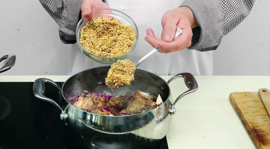 Добавьте ореховую заправку к мясу, перемешайте деревянной ложкой, разведите бульоном до состояния густой похлебки, дайте покипеть на маленьком огне 6 минут перед подачей.