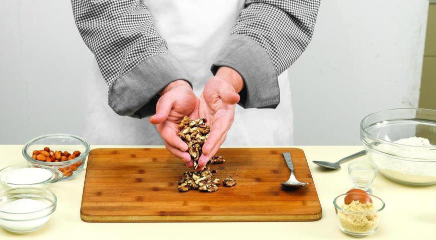 Прокалите на сухой сковородке грецкие орехи, потрите их между ладонями, чтобы удалить шелуху, нарежьте орехи крупными кусочками.