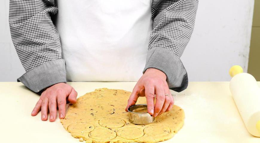 Раскатайте тесто на поверхности, присыпанной мукой. Вырежьте формочками круглое печенье, выложите на смазанный маслом противень и выпекайте в разогретой до 185 °С духовке до золотистого цвета, примерно 22 минуты.