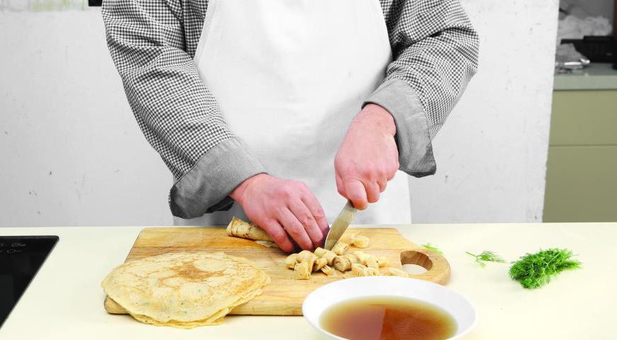 Каждый блинчик аккуратно скрутите в плотную трубочку и нарежьте на полоски шириной около 1 см. Подогрейте бульон, разлейте его по порционным тарелкам, добавьте блинные полоски и украсьте мелко нарезанной зеленью укропа перед подачей.