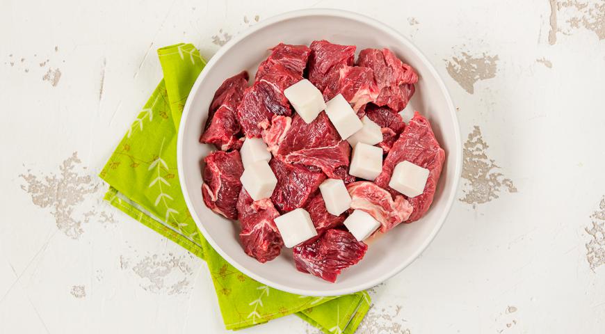 Выберите вырезку без лишних пленок и сухожилий. Тщательно промойте мясо и сало под холодной водой, затем нарежьте их на крупные кусочки, чтобы удобнее было прокручивать через мясорубку.
