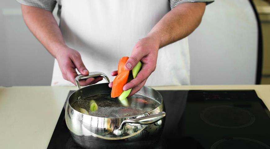 Добавьте очищенные и нарезанные крупными кусками морковь и порезанный стебель лука-порея (обязательно проверьте отсутствие песка внутри). Залейте 3,2 литра воды, доведите до кипения, посолите и варите на медленном огне около 1 часа 40 минут, чтобы мясо стало мягким.