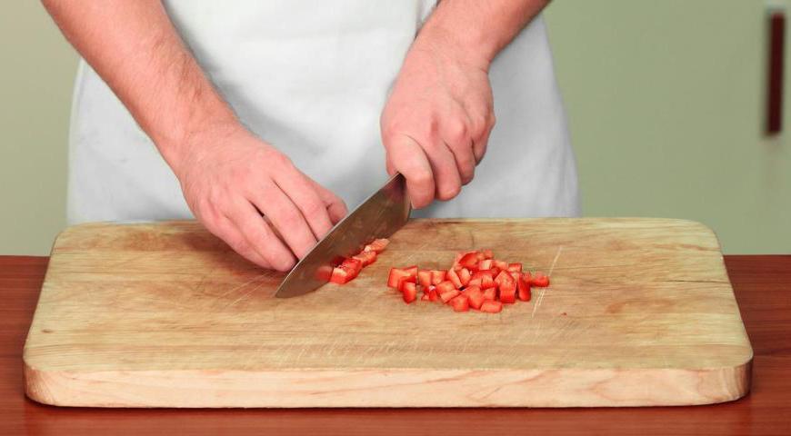 Очистите морковь и нарежьте ее крупными кусочками. Удалите семена и сердцевину у сладкого перца, мякоть нарежьте кубиками. Помидоры бланшируйте в кипятке на 30 секунд, снимите кожицу и нарежьте крупно.