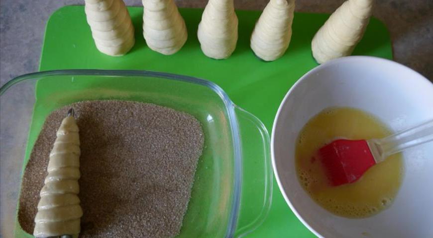 Каждую заготовку смазать яйцом и обвалять в корично-сахарной смеси.