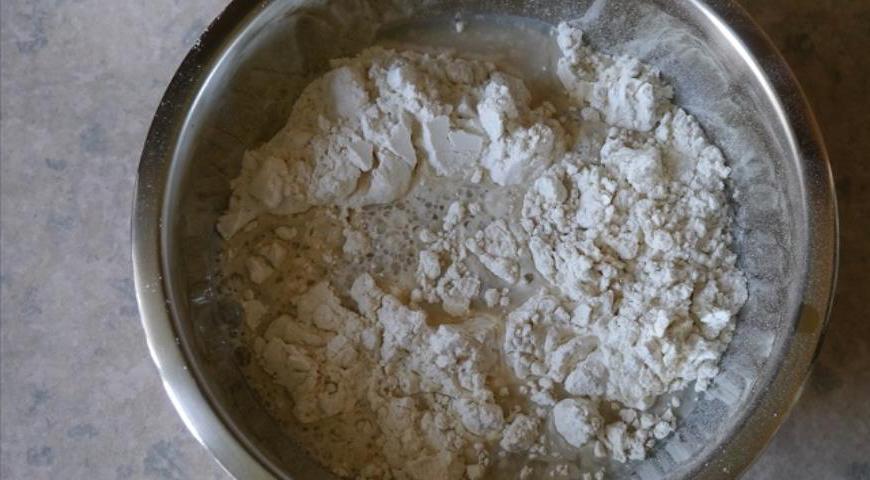 Влить дрожжевую массу в миску с мукой и начать аккуратно перемешивать.