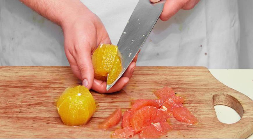 Вырежьте дольки апельсинов и грейпфрута, аккуратно разделяя их по пленкам. Сохраняйте весь выделяющийся сок. По завершении процедуры выжмите остатки цитрусовых, чтобы получить максимальное количество жидкости.