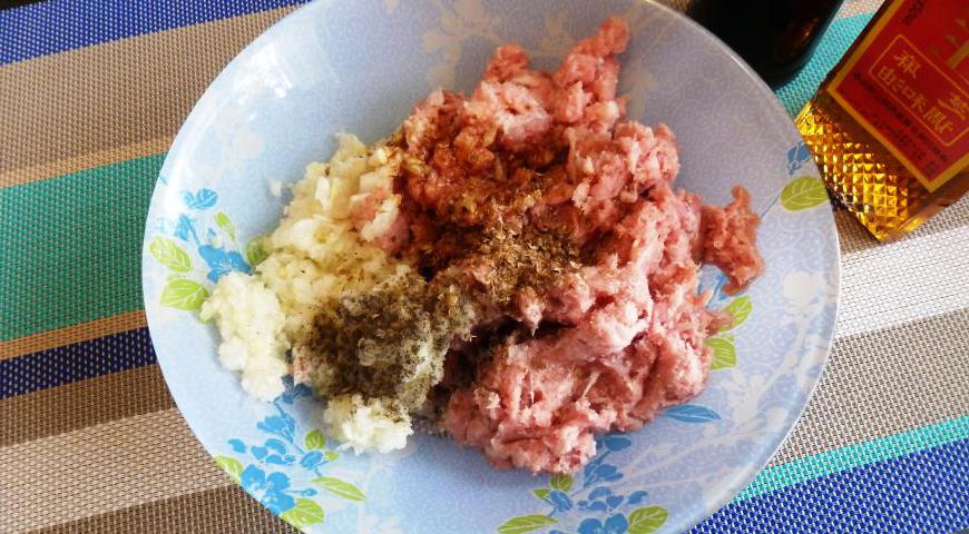 В большой миске смешайте свиной фарш, измельченный лук, чеснок и имбирь (можно всё перебить в блендере для однородности). Добавьте кунжутное масло, соевый соус, черный перец и размолотый кориандр. Хорошо перемешайте до получения плотного фарша.