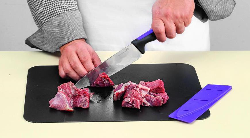 Нарежьте баранью тушку на небольшие кусочки, чтобы они быстрее проварились и сохранили сочность.