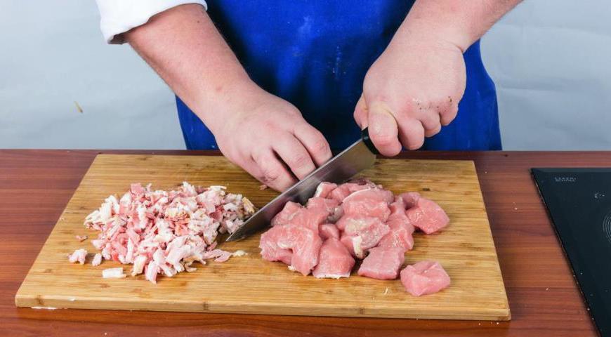 Нарежьте свинину кубиками среднего размера. Мелко порежьте бекон. Очистите репчатый лук и нарежьте его небольшими кубиками. Аналогично нарежьте сельдерей.