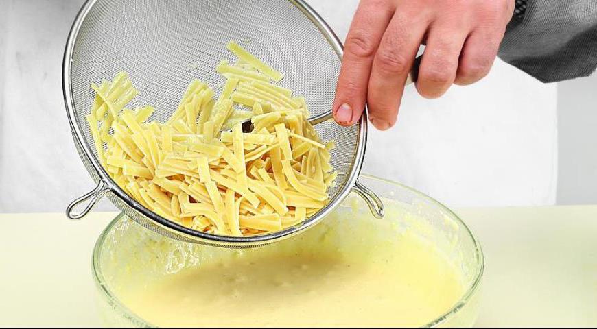 Не прекращая взбивать, аккуратно всыпьте манную крупу тонкой струйкой. После этого аккуратно смешайте творожно-яичную массу с отваренной лапшой.