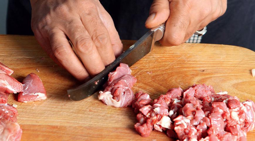 Промойте рис под проточной водой и замочите его на полчаса. Снимите мясо с костей, сохраняя немного мяса на костях. Нарежьте мясо кубиками размером примерно 6 мм. Курдючный жир разделите на две части: одну нарежьте такими же кубиками, а другую — кубиками размером 2 см.