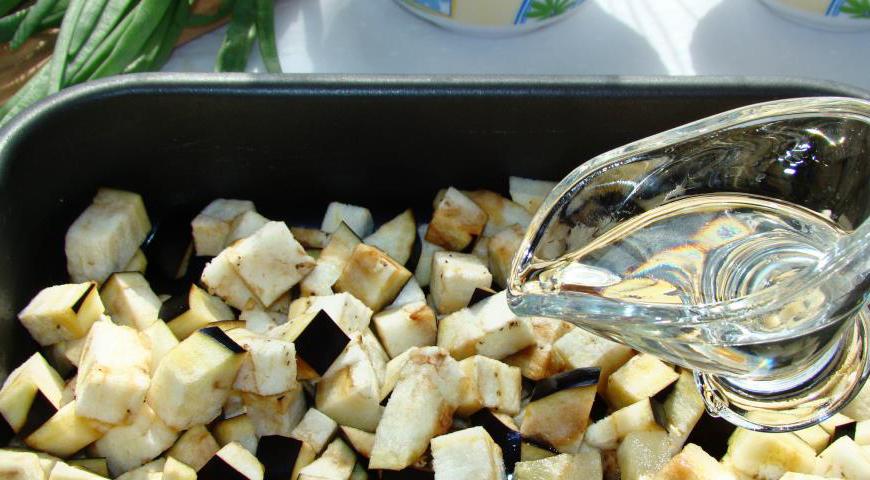 Хорошо промойте баклажан, нарежьте его на небольшие кубики. Посолите немного и слегка сбрызните растительным маслом. Выложите на противень и запекайте в предварительно разогретой духовке около 20 минут при температуре 180°C до мягкости.
