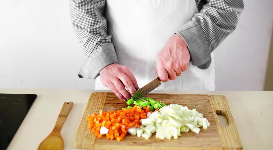 Очистите лук, чеснок и морковь, нарежьте их небольшими кубиками. Также нарежьте сельдерей. Соленые огурцы очистите от кожицы, разрежьте их вдоль на четвертинки и порежьте поперек кусочками толщиной примерно 8–9 мм.