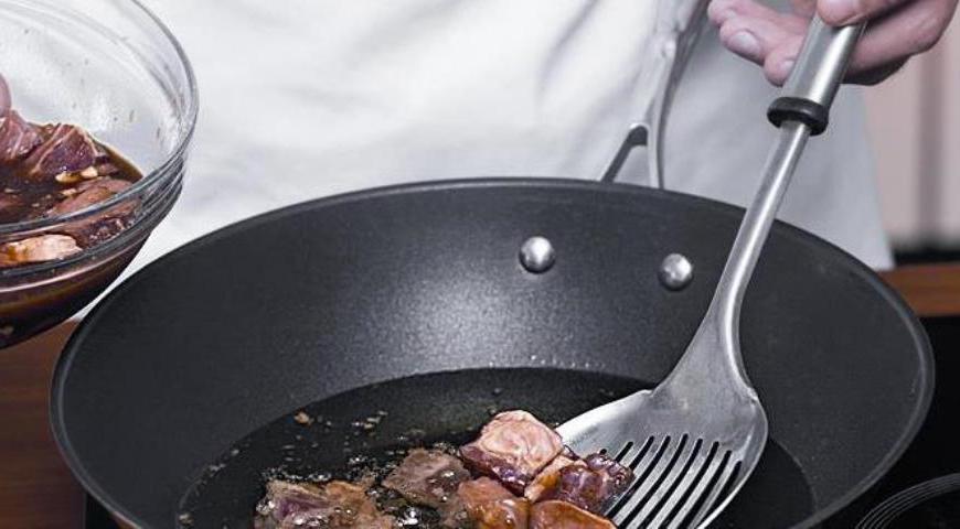 В воке нагреть растительное масло слоем 4.5 см. Мясо вынуть из маринада шумовкой небольшими порциями и обжаривать до золотистой корочки со всех сторон при умеренном огне. Готовое мясо переложить на бумажные полотенца для удаления лишнего жира.