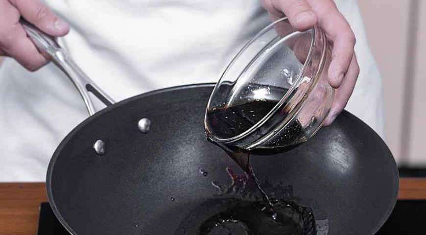 После готовности всего мяса слить масло из вока. Влить 100 мл воды, темный соевый соус и соус хойсин, перемешать. Добавить свинину, перемешать и довести соус до кипения. Снять с огня.
