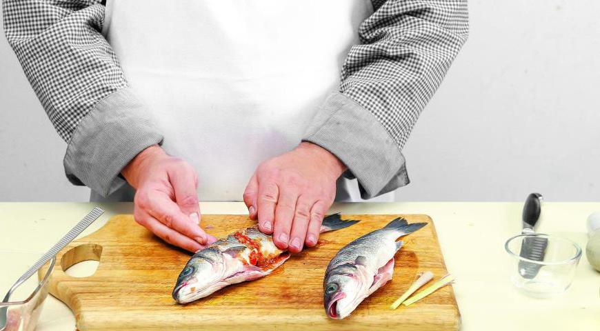 Смешайте пасту с рыбным соусом и маслом. Нанесите эту смесь на рыбу, втирая в надрезы. В каждую тушку положите оставшиеся стебли лемонграсса и оставьте мариноваться минимум на 25 минут.