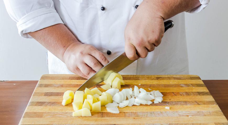 Очистите лук и картофель. Лук нарежьте полукольцами, картофель – кубиками размером примерно 2,2 см.