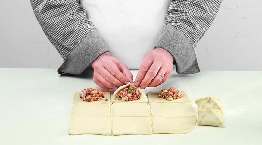 Разогрейте духовку до 185 °C. Раскатайте тесто и разрежьте на небольшие кусочки. Выложите начинку в центр каждого куска, соедините края и защипните их. Расположите пирожки на противне с небольшим интервалом между ними и оставьте расстаиваться в теплом месте на 15 минут.