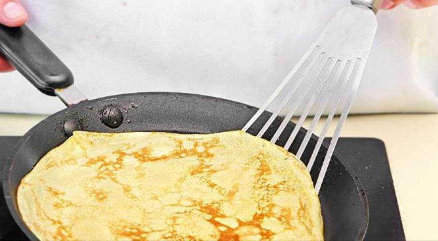 Горячую сковороду (желательно чугунную) смажьте маслом и выпекайте максимально тонкие блинчики, избегая их пережаривания. Когда все блинчики будут готовы, равномерно распределите рикотту, присыпьте клюквой и аккуратно заверните каждый блинчик конвертом. Подавайте сразу же после приготовления.