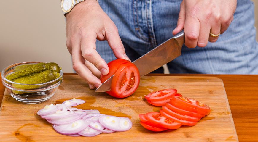 Нарежьте кольцами крупные сезонные помидоры, красный лук, маринованные или свежие огурцы. Подготовьте салатные листья.