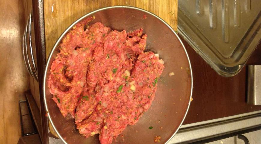 Добавьте в массу говяжий фарш и разбейте туда куриное яйцо. Хорошенько вымесите все руками до однородной консистенции.