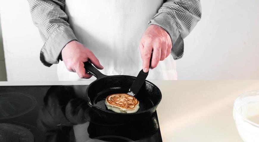 Разогрейте сковороду на среднем огне, слегка смажьте маслом. Выкладывайте тесто порционно, используя столовую ложку. Жарьте оладьи до золотистой корочки с обеих сторон. Готовые изделия держите в тепле перед подачей.