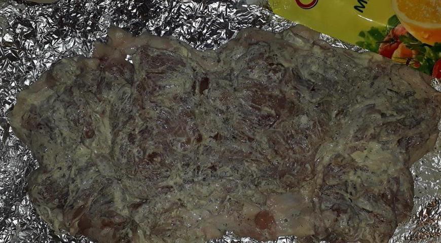 Разверните мясо, расправьте его на ровной поверхности, и выложите на лист фольги.