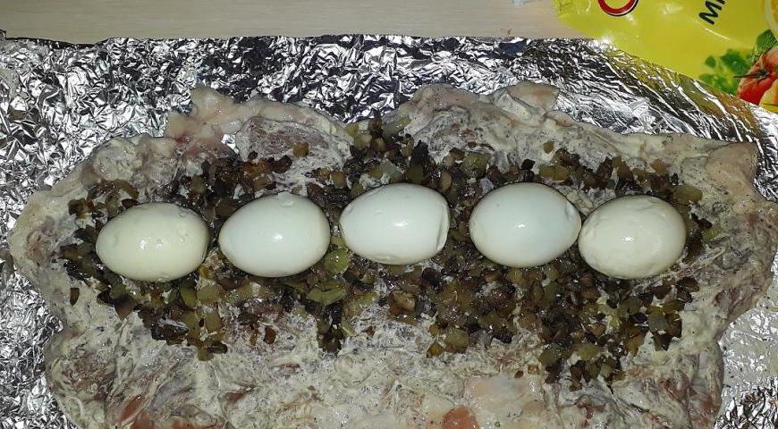 Рядом, поверх начинки, аккуратно разместите отварные яйца, предварительно очищенные от скорлупы.