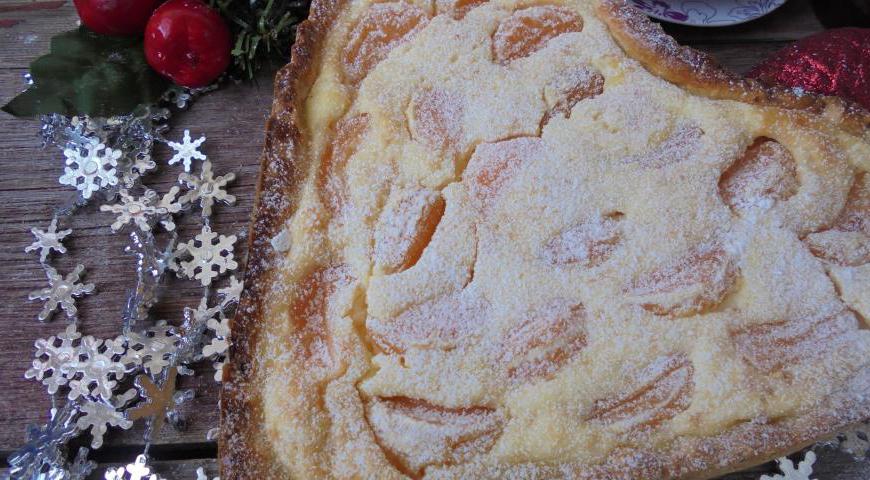 Посыпьте верх пирога тростниковым сахаром. Отправьте форму в предварительно разогретую духовку до температуры 180 °C. Выпекайте в течение 40–45 минут до золотистого цвета. После выпечки полностью остудите пирог, перед подачей присыпьте сахарной пудрой. Нарежьте на порционные кусочки и подавайте к чаю или кофе.